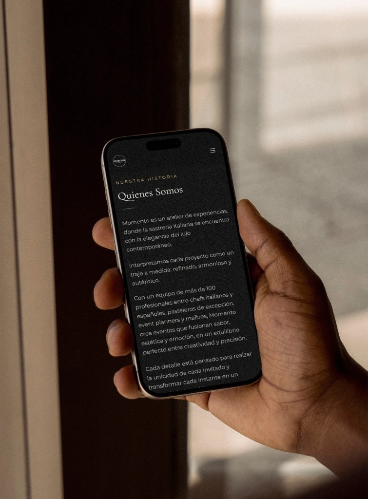 Telefono tenuto in mano, con la pagina Quienes Somos di Momento Catering.