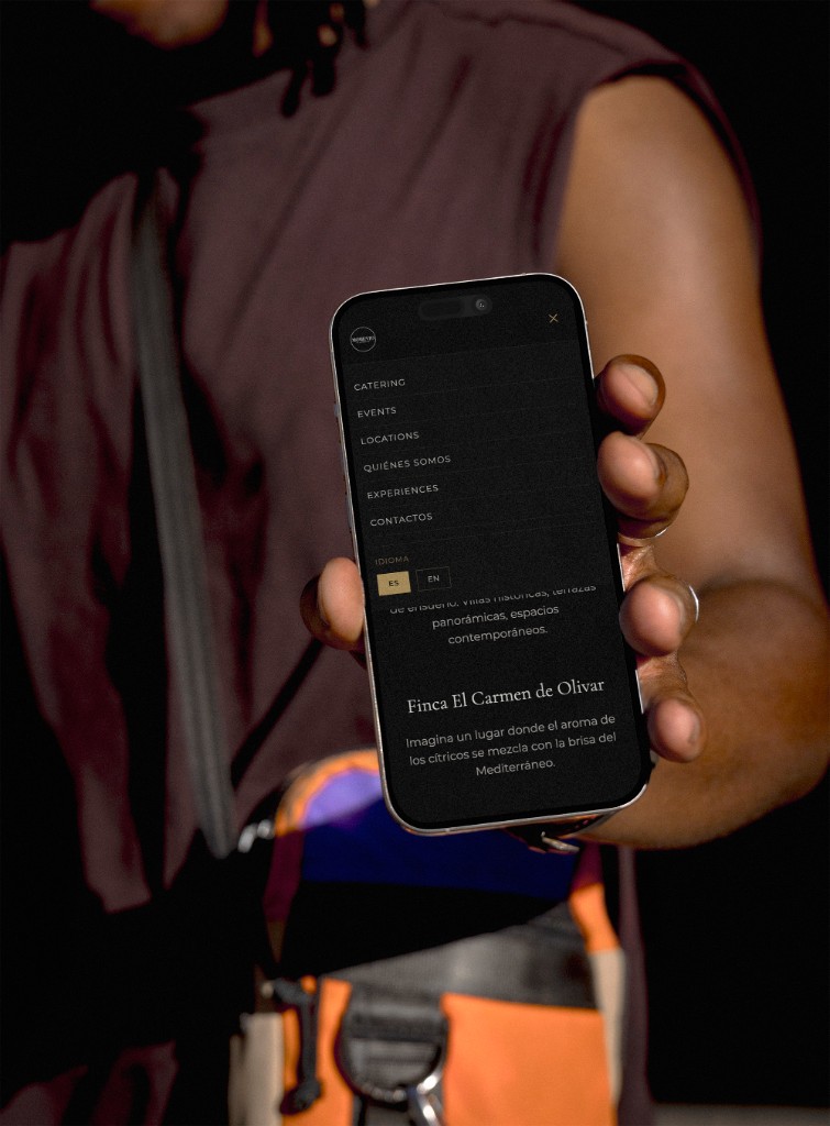 Telefono con il menu di Momento Catering aperto su una location.