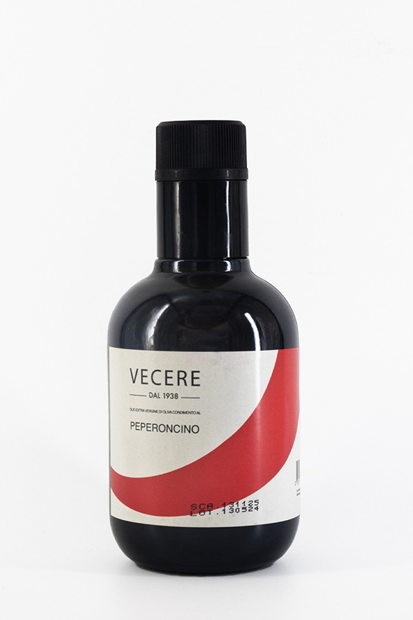 Bottiglia nera di condimento al peperoncino Vecere, etichetta bianca con curva rossa.